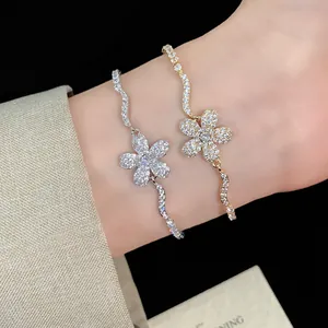 Close-up of elegant flower bracelets with sparkling cubic zirconia stones on a wrist.