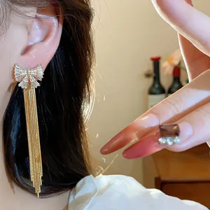 Gros plan de boucles d'oreilles nœud en zircon plaqué or 18 carats à longs glands