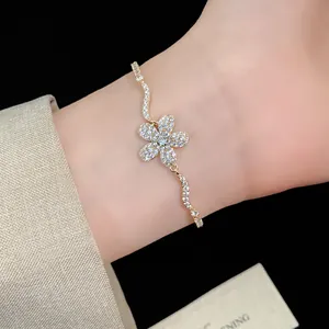 Detailed view of an exquisite gold zircon flower bracelet worn on a female wrist.
