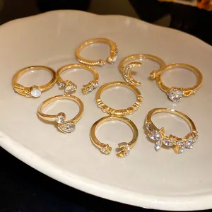 Detailansicht eines 9-teiligen goldenen Ring-Sets mit Herz-, Mond- und Sternmotiven.