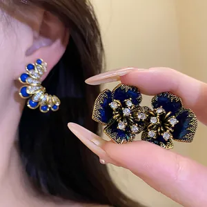 Detailed macro view of vintage blue enamel flower earrings with sparkling rhinestones