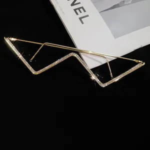 Detailed view of gold W-shaped rimless glasses frame with glittering rhinestones