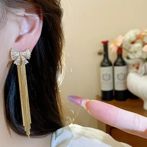 Détail de boucles d'oreilles nœud papillon en plaqué or 18k avec zircons étincelants