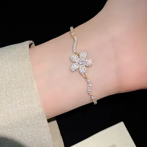 Detailed close-up of a sparkling gold zircon flower pendant bracelet on an elegant wrist