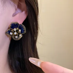 Macro shot of vintage royal style flower earring with blue enamel and rhinestones