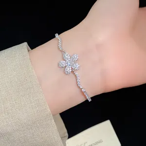 Close-up detail of a sparkling silver-tone zircon flower pendant bracelet on a wrist