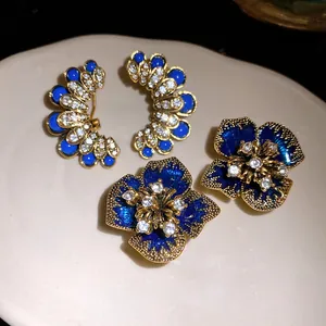 Close-up of vintage flower and fan earrings with blue enamel and rhinestones