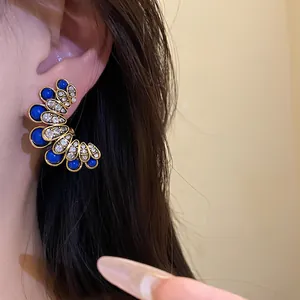 Close-up of vintage flower stud earrings with blue stones and brilliant rhinestones