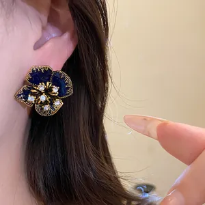 Macro view of dark blue vintage flower stud earring with rhinestones