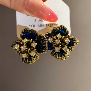 Close-up detail of vintage floral earrings with navy enamel and sparkling rhinestones