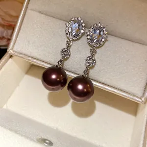 Detailed close-up of elegant brown pearl drop earrings with sparkling rhinestone studs
