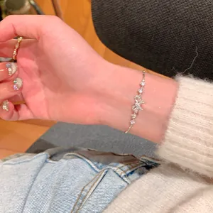 Elegant French bow zircon bracelet for women shown on a wrist with casual outfit.