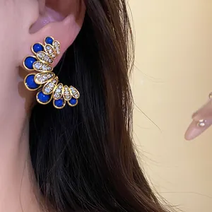 Vintage gold-tone flower stud earrings with blue stones and sparkling crystals for women