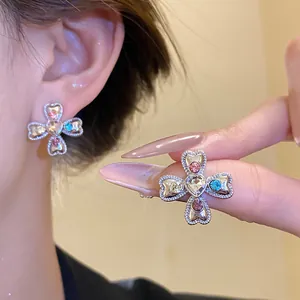 Detail view of vintage heart cross flower earrings with colorful crystals and stones