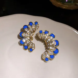 Close-up of vintage palace style fan-shaped earrings with blue beads and crystals.