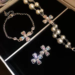 Close-up detail of retro rhinestone cross flower jewelry set with pearls in box
