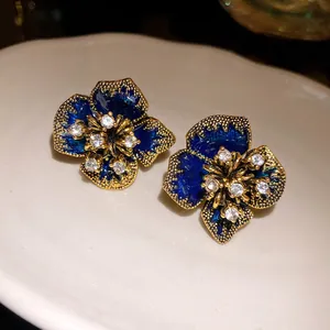 Detail of vintage flower stud earrings with blue enamel and sparkling rhinestones