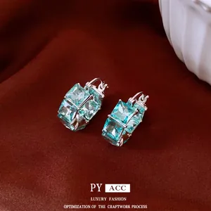 Elegant vintage square blue zircon huggie earrings on a luxury brown silk background