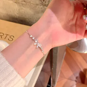 Detail view of an elegant silver bowknot zircon bracelet worn on a woman's wrist