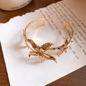 Elegante brazalete abierto de metal dorado vintage con diseño de estrella de mar retro