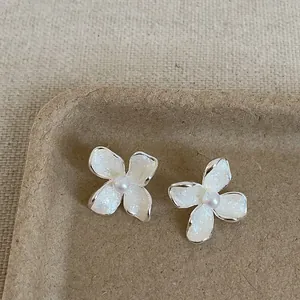 Close-up view of French style flower pearl stud earrings with shimmering white petals