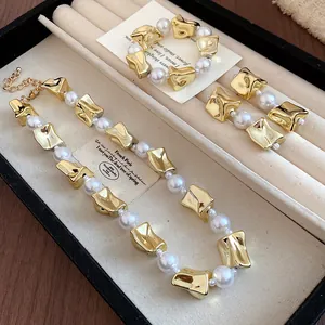 Elegant vintage jewelry set with irregular gold pieces and pearls in a display box