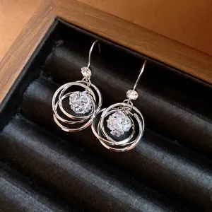 Primo piano di eleganti orecchini color argento con anelli in zircone in un portagioie