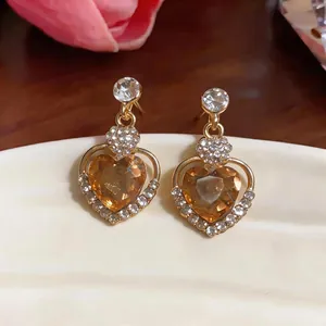 Elegant heart stud earrings featuring amber gems and brilliant rhinestone accents.