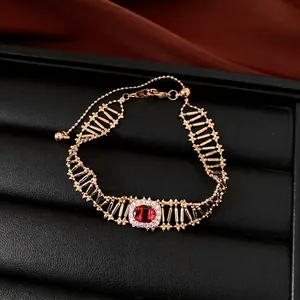 Bracciale vintage placcato oro con maglia traforata e pietra centrale di zircone rosso quadrato.