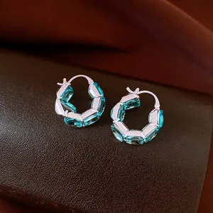 Macro view of vintage style hoop earrings featuring square blue zircon stones in silver