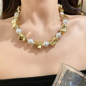 Elegant vintage pearl necklace with irregular gold geometric beads on model's neck