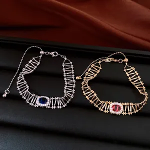 Dettaglio di bracciali vintage in zircone traforati in tonalità argento e oro con pietre ovali