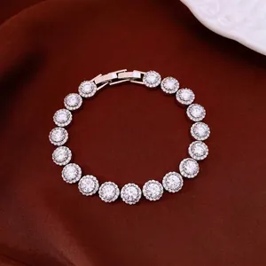 Luxury gold plated bracelet with circular halo-set cubic zirconia stones on dark satin.
