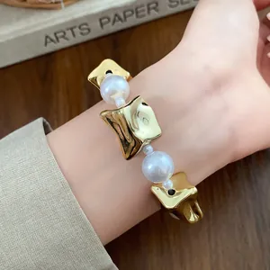 Close-up detail of a vintage court style bracelet featuring gold cubes and white pearls