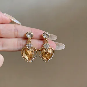 Detailed macro view of champagne heart-shaped crystal earrings with elegant gold finish