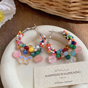 Colorful beaded hoop earrings with butterfly charms in vibrant summer dopamine style