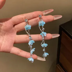 Close-up of elegant blue resin flower tassel earrings with clear zirconia