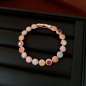 Macro view of a colorful zircon round bracelet with a halo setting on a black jewelry tray.