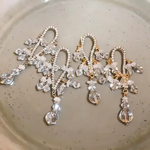 Elegantes pendientes de borla dorados de estilo francés con diamantes y cristales claros.