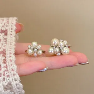 Close-up detail of vintage style cluster rings featuring white faux pearls and crystals