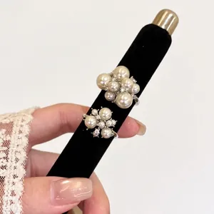 French vintage style pearl flower cluster rings on a black velvet display mandrel