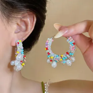 Detailed view of dopamine style colorful beaded hoop earrings decorated with freshwater pearls