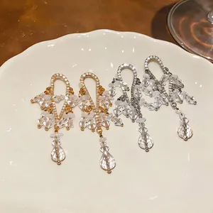 Primer plano de elegantes pendientes de borla franceses con cristales brillantes.