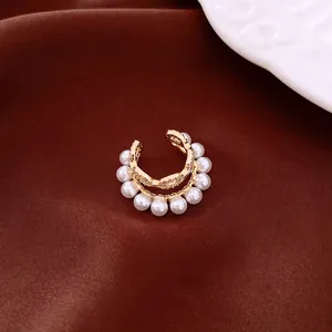 Detailed view of elegant double-layered gold ear cuff with white pearls and sparkling zircons