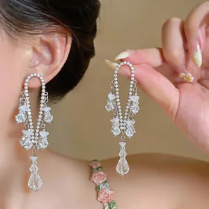 Vista detallada de pendientes con borlas de estilo francés y pedrería brillante plata
