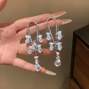 Primer plano de elegantes pendientes de borla de estilo francés con pedrería y gotas de cristal