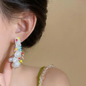 Close-up of dopamine style pearl earrings with colorful beads and silver needles