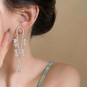 Primer plano del pendiente de borla de pedrería con colgantes de cristal en la oreja
