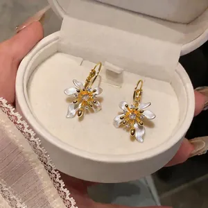 Elegant zircon flower earrings with white enamel petals in a cream velvet jewelry box