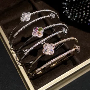 Close-up of elegant 18k gold plated double-layer bracelets with zirconia flower motifs.